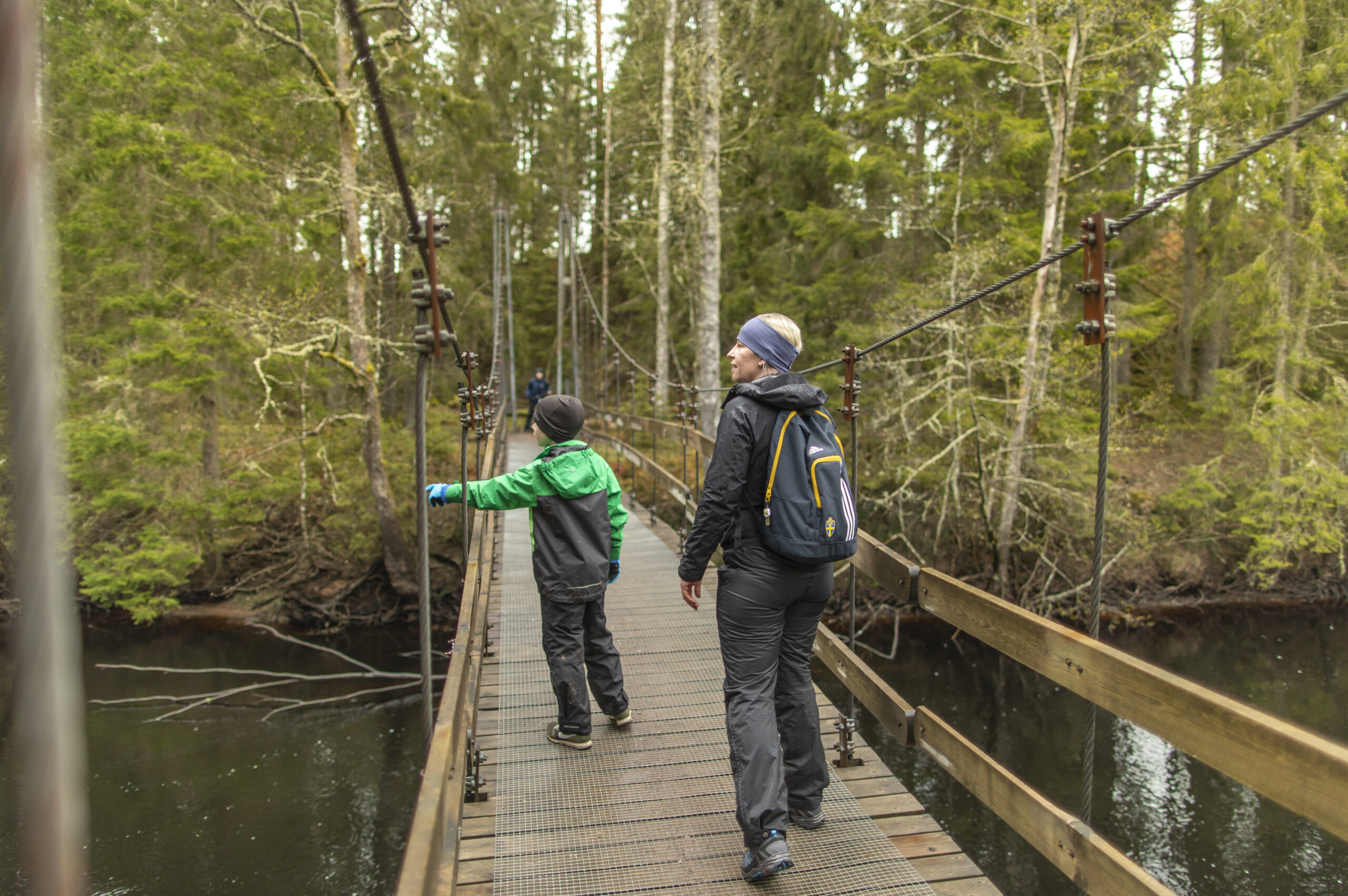 Mamma och son på hängbron över ån Nissan, leden de går heter Pink Lady och går runt Algustorpasjön och förbinder Hestraviken med Isaberg