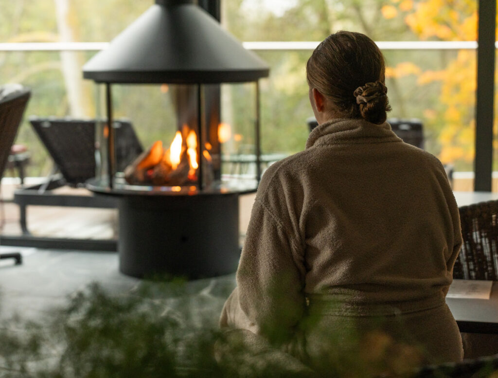 En tjej njuter av brasan i Riverside spa. Dagspa på Riverside Spa vid Hestraviken hotell i Småland.