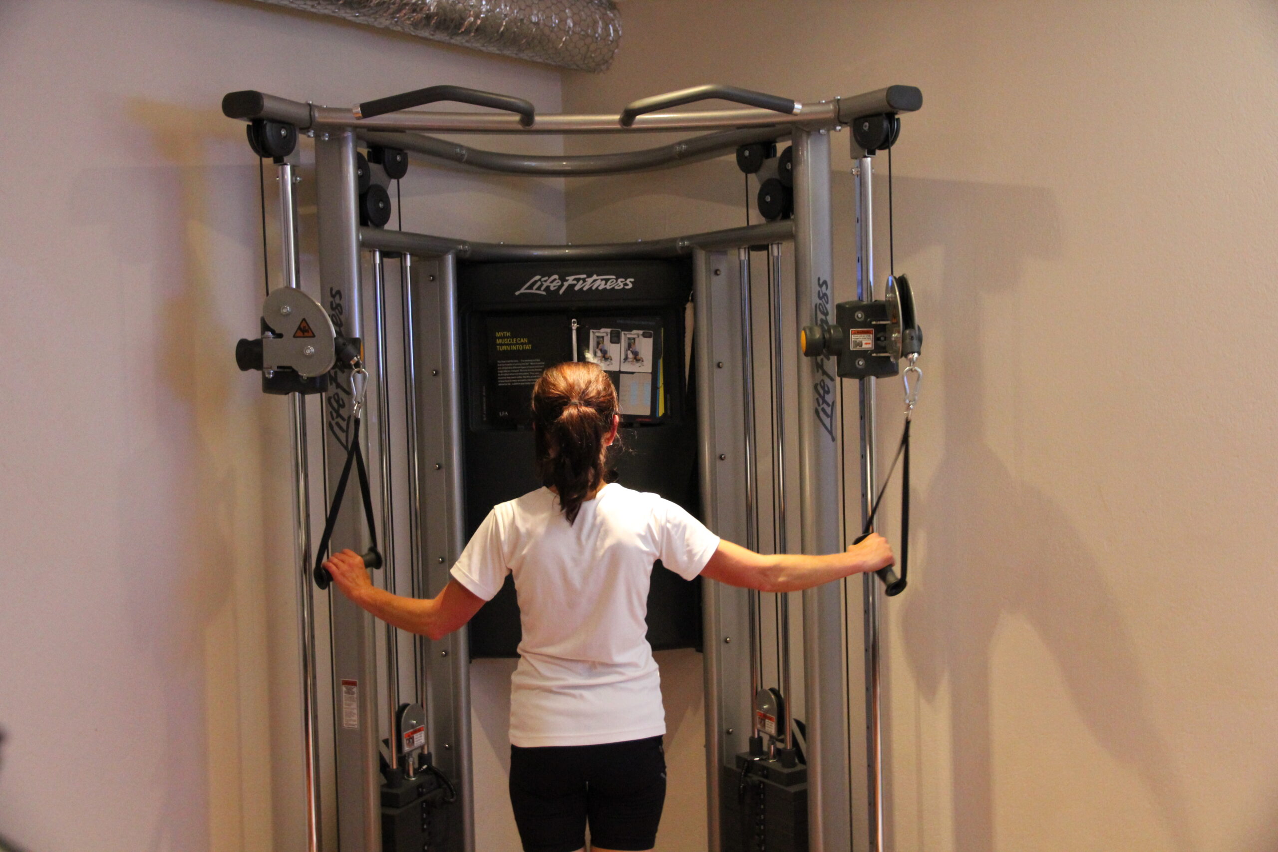 En kvinna tränar i gymmets multimaskin på Hestravikens hotell.