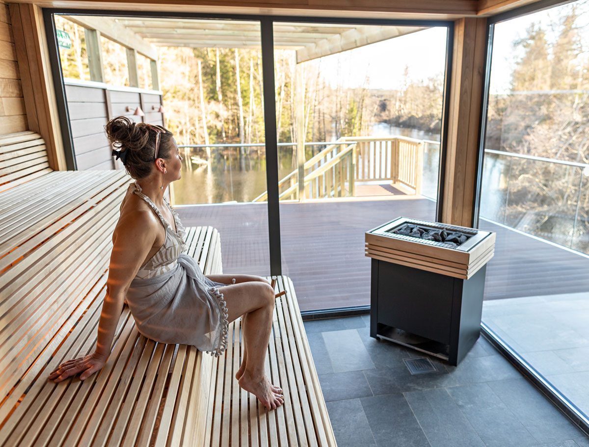 Person som njuter av bastu på Riverside Spa på Hestraviken, i en avkopplande och naturskön miljö.