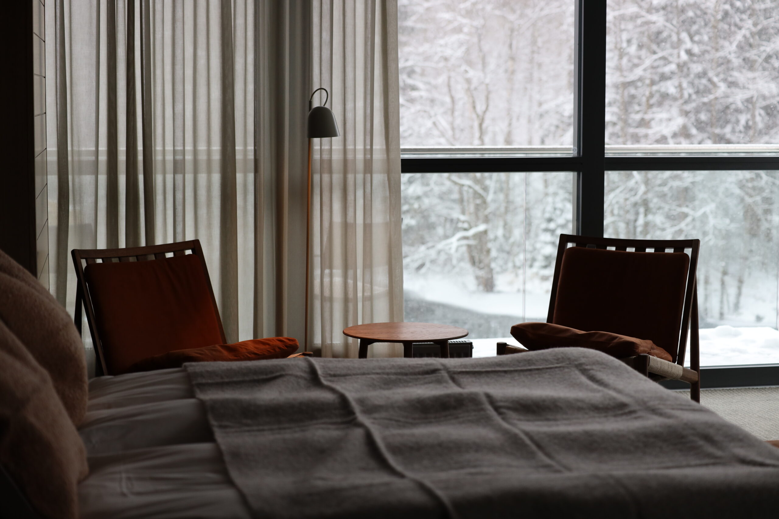 Bilden är tagen en vinterdag, där skogen och är täck av snö, rummet visar interiör i nya Spa villan vid floden Nissan, panorama fönster, soffgrupp, Carpediem continentalsäng 180 bred, balkong vid floden och Spa terassen, 2 extrabäddar i sängskåp 80 breda, skrivbord och LED TV