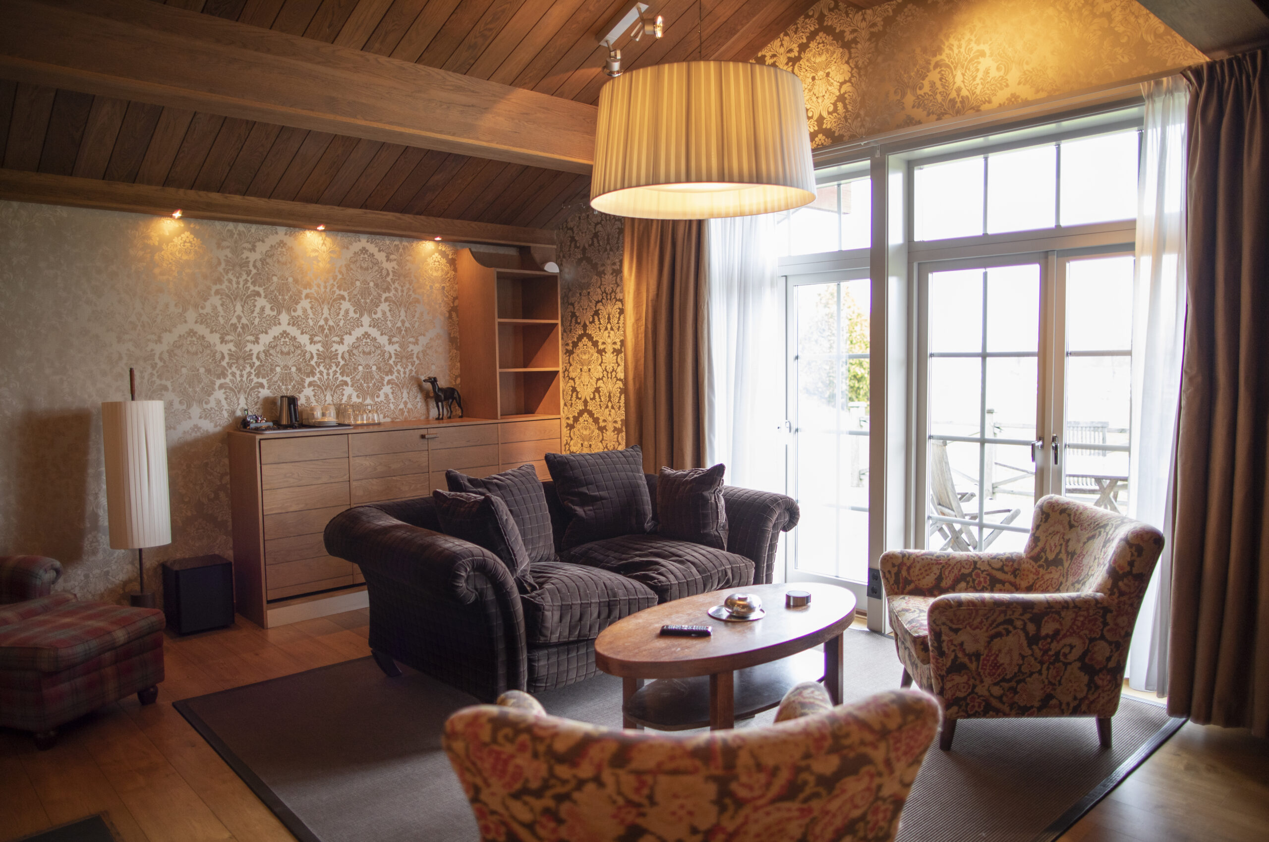 Lodge Sviten på Hestraviken hotell i Småland. Soffgruppen i den stora salongen med utsikt och kamin.