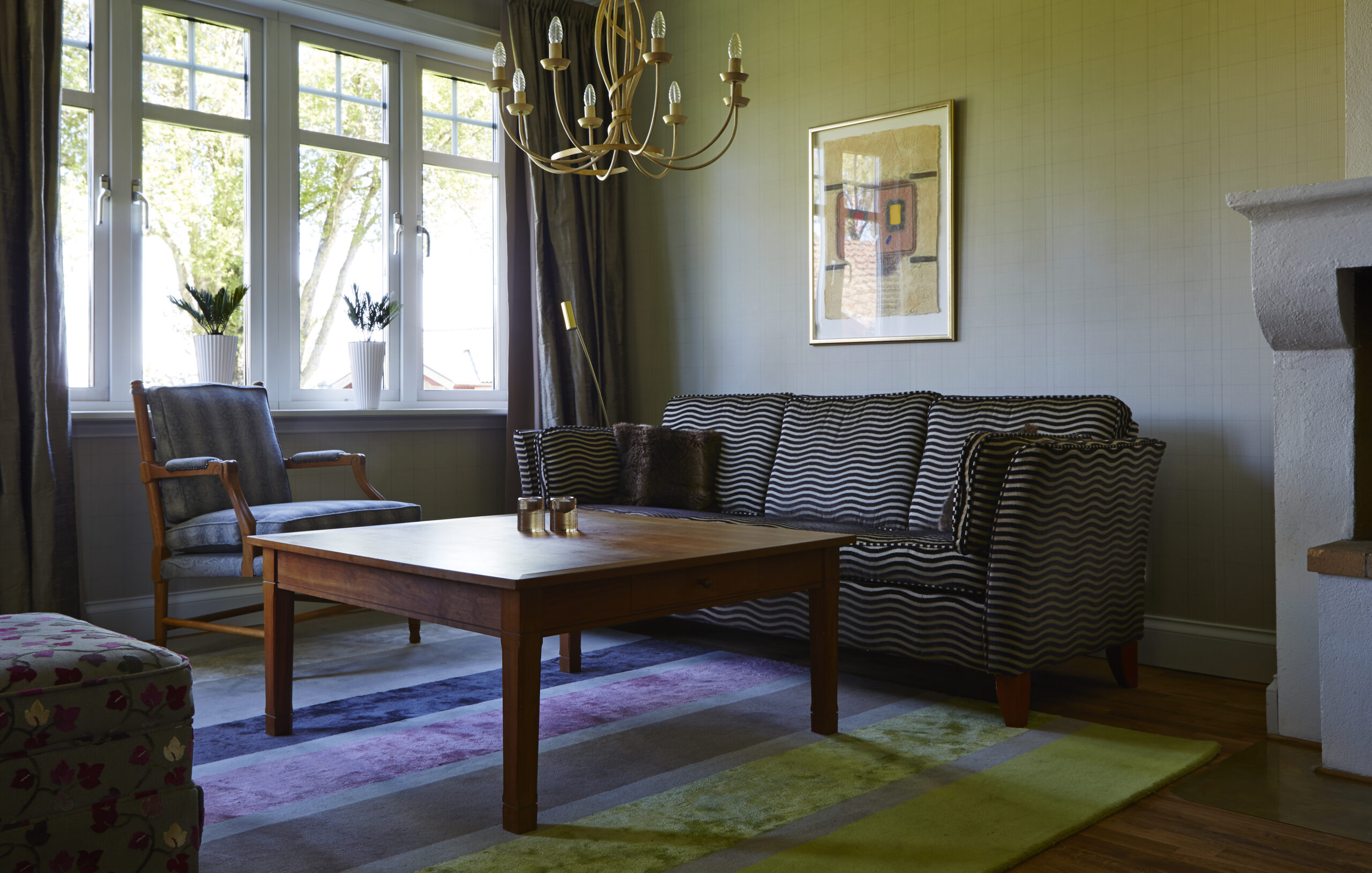 Salongsdel i juniorsvit. Soffgrupp med bord och ljuslyktor. Vackert hotellrum på Hestraviken Hotell & Spa nära Isaberg i Småland