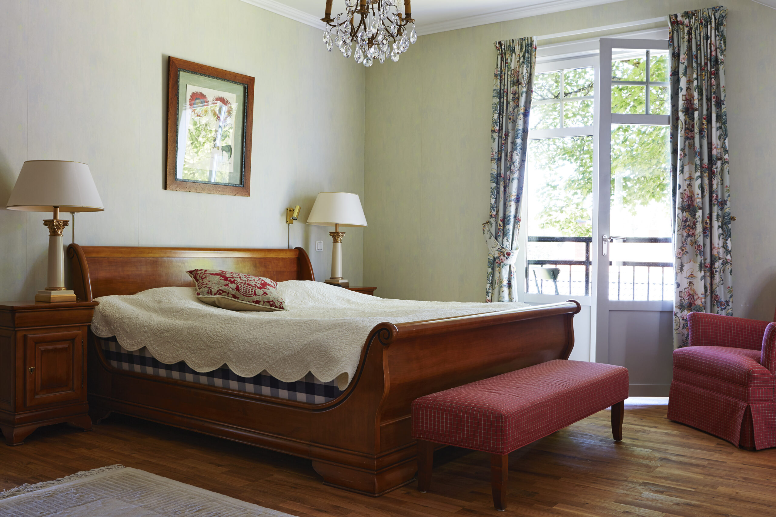 Vackert sovrum med Hästens dubbelsäng i Grange sängram. Tavla med blomma. Fransk balkong med öppen balkongdörr. Lyxigt sovrum på Hestraviken hotell & Spa vid Isaberg I Småland.