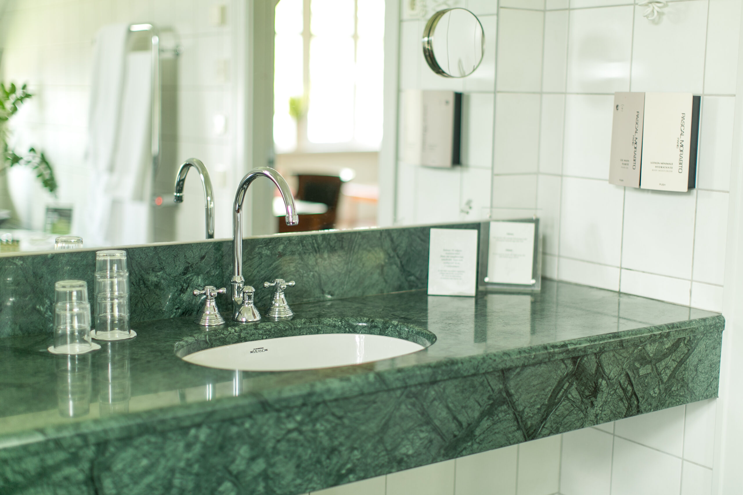 På bilden syns ett handfat och kran omgivna av italiensk marmor. Badrum i svit penthouse i herrgårdsvillan på Hestraviken hotell och spa vid Isaberg I Småland.