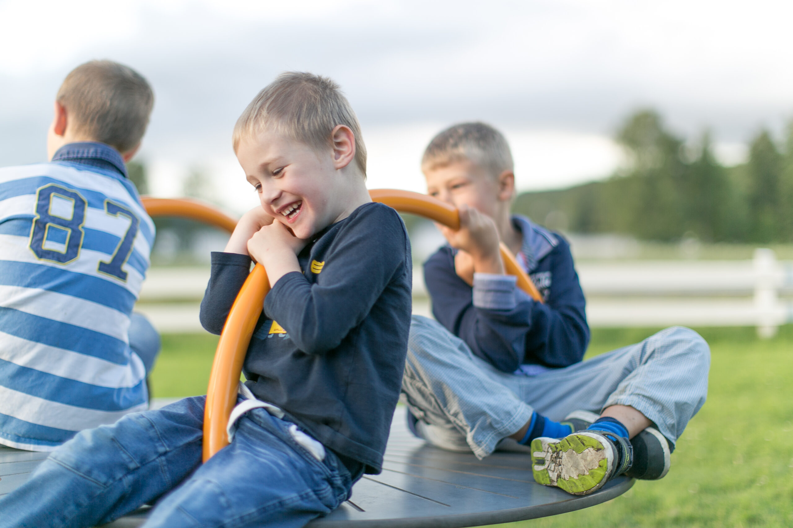 Tre barn som leker i karusellen på Hestraviken hotell lekplats, en familjevänlig destination vid Isaberg i Småland.