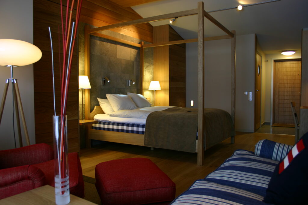 Ett hotellrum i Villa 4 på Hestraviken hotell i Småland. Säng, fåtölj och soffa