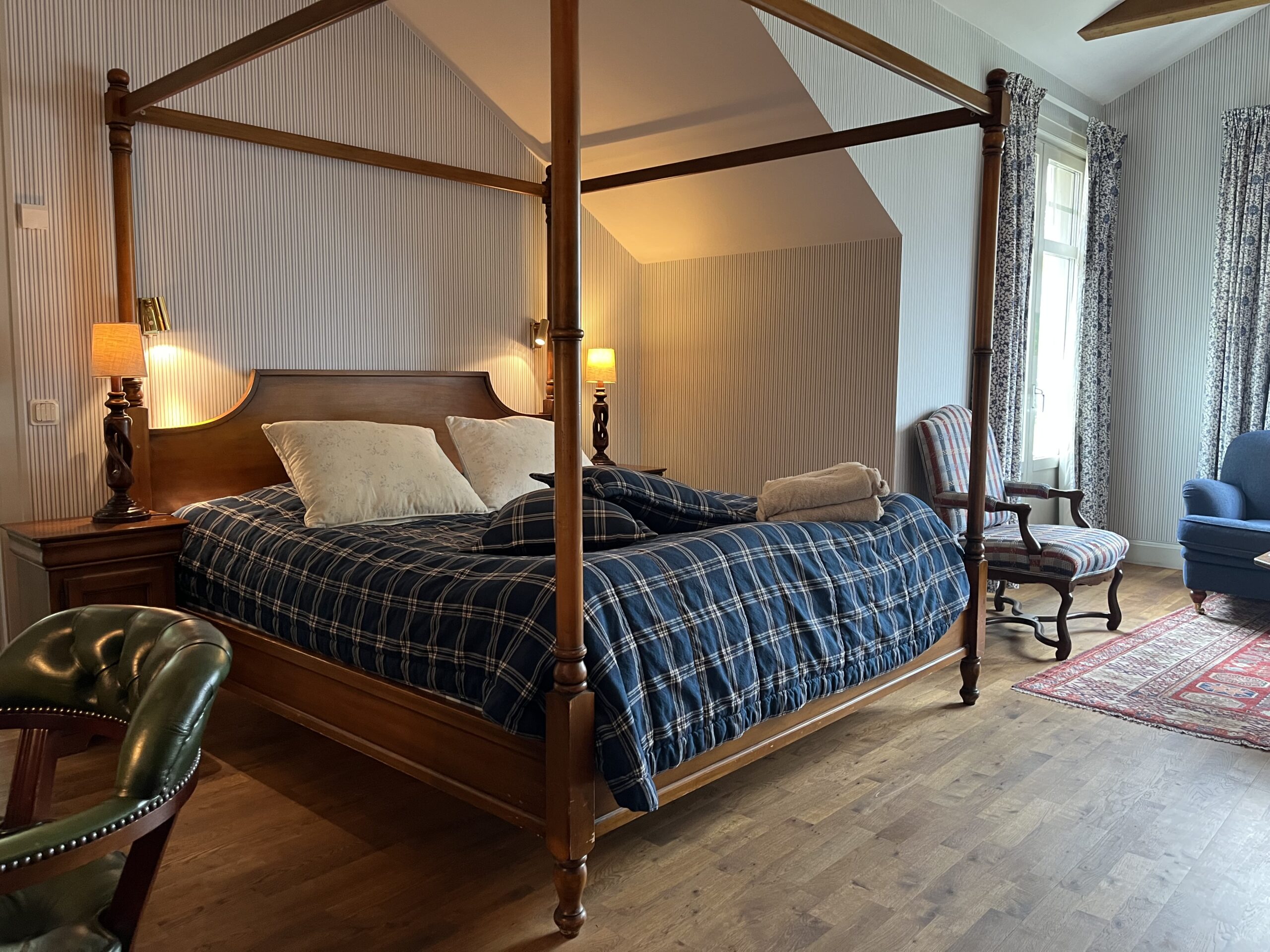 interiör Juniorsvit Deluxe, Hästens himmelsäng, karmstol vid soffgruppen samt skinnbeklädd karmstol vid skrivbordet