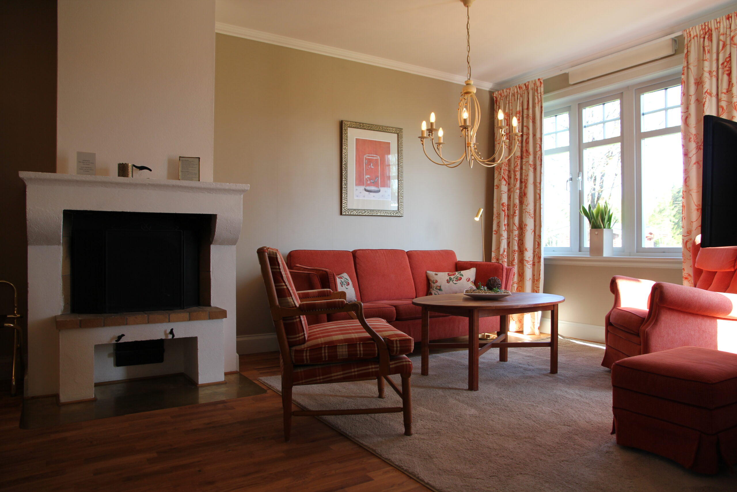 Interör i salong Svit Penthouse med braskamin, soffgrupp med fåtöljer, LED Tv samt mjuk matta på golvet