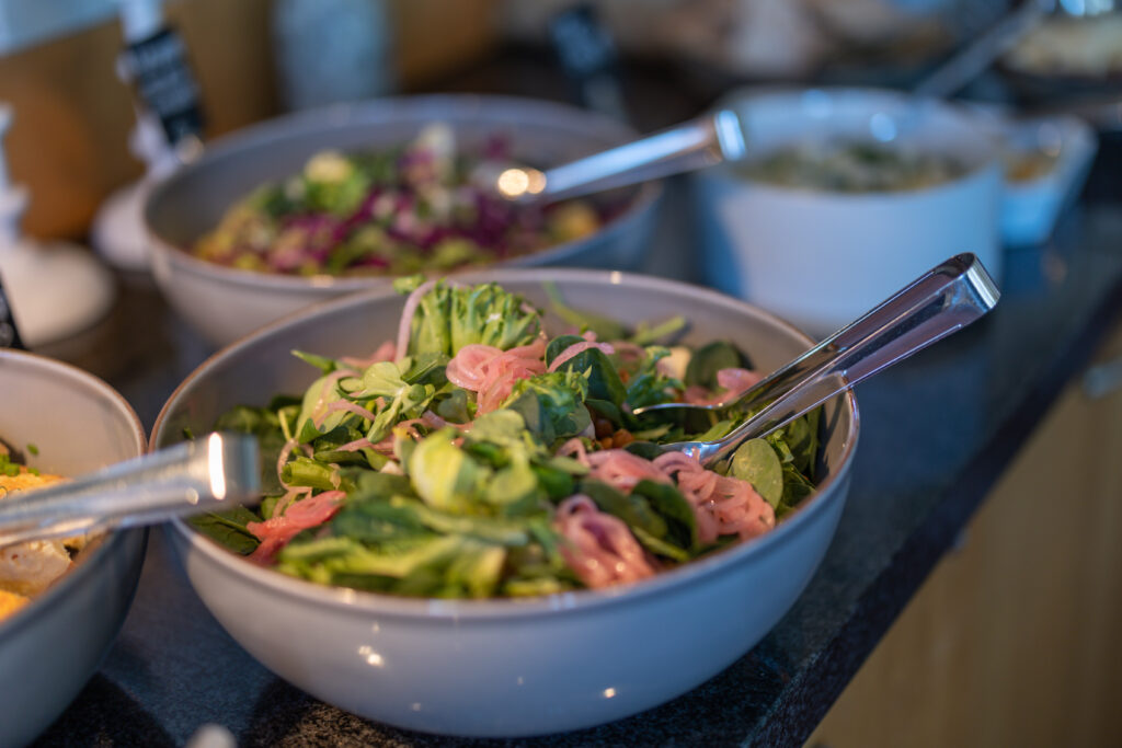 Fräsch sallad i generösa skålar redo att serveras våra Lördagslunchgäster