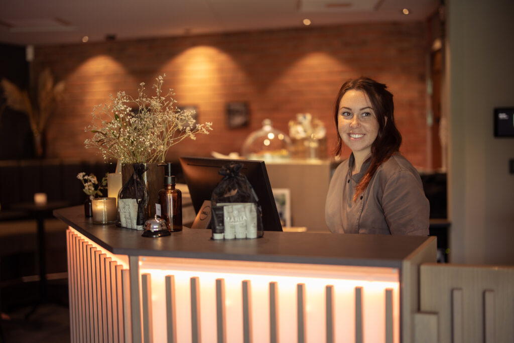 Tjej som välkomnar gäster i Riversides spareception Hestraviken.