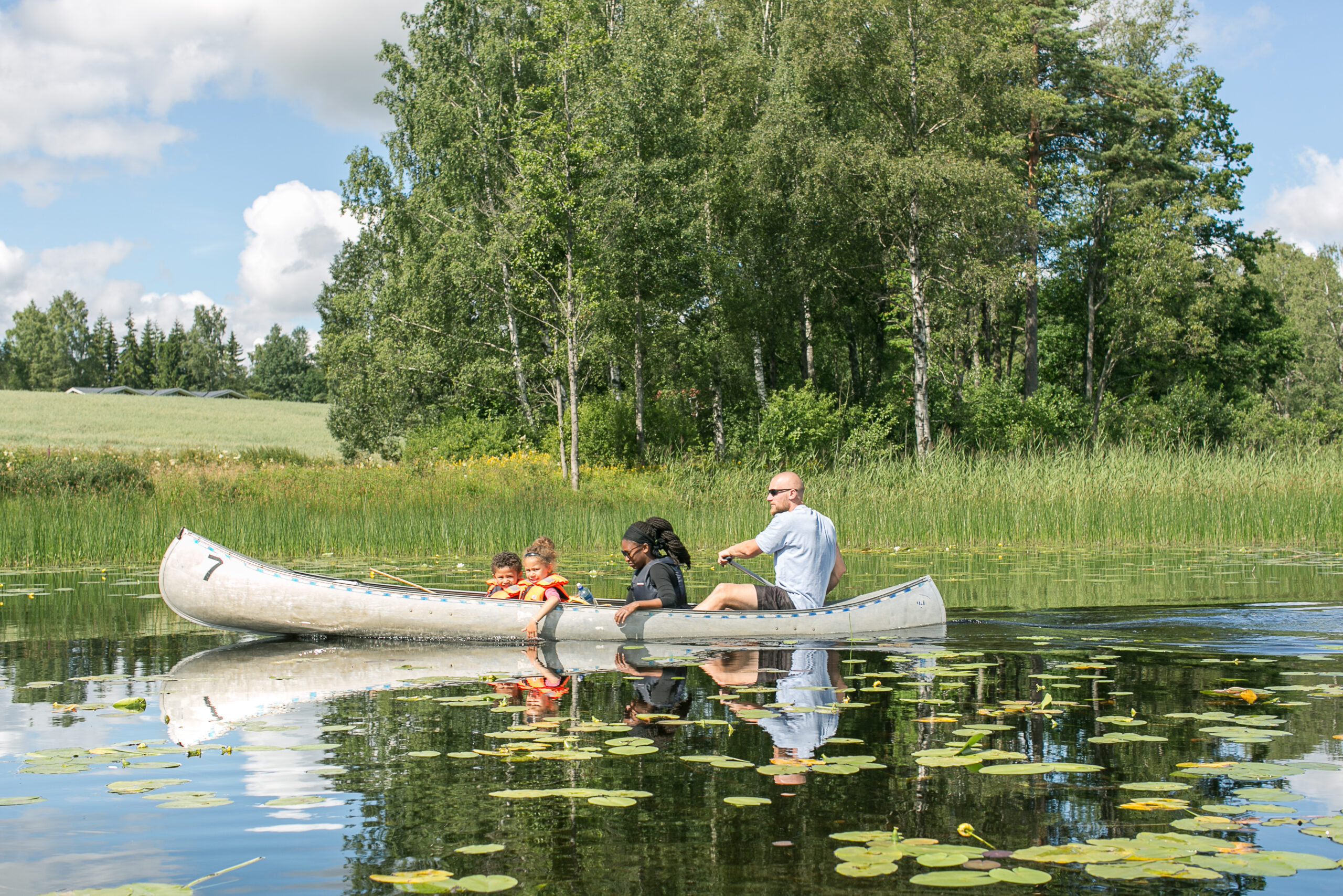 Familj paddlar kanot i Algustorpasjön vid Hestraviken