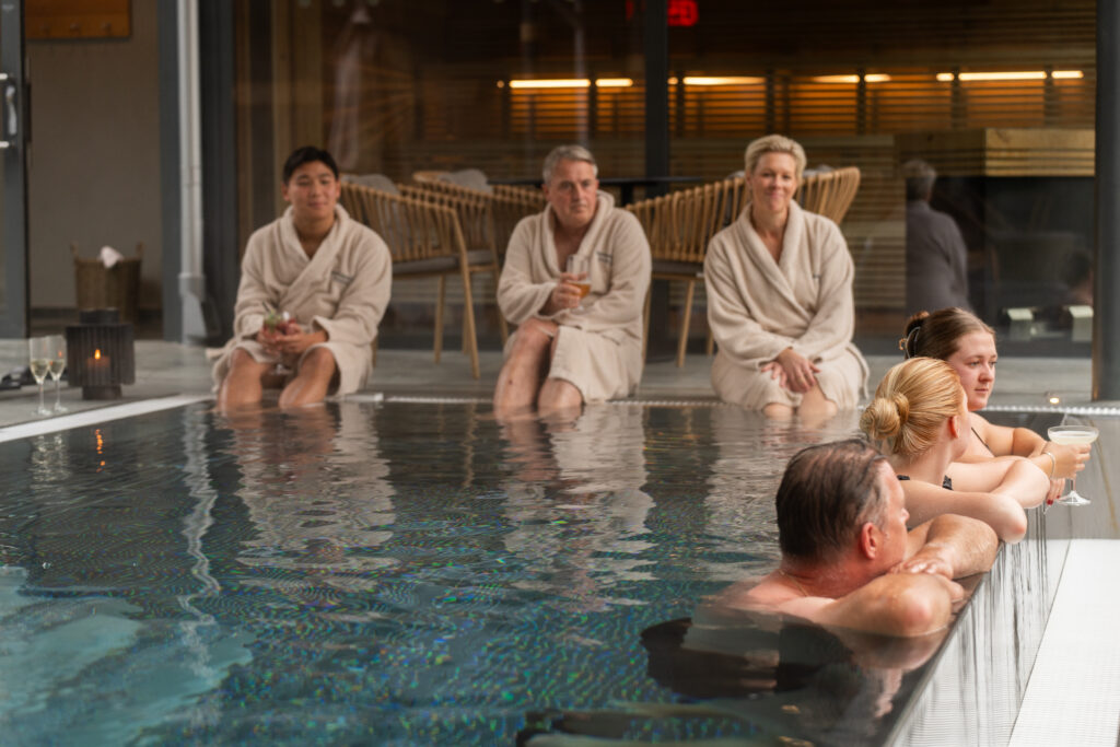 Konferensgrupp i infinitypoolen på Riverside Spa på Hestraviken hotell vid Isaberg, en plats för avkoppling och teambyggande aktiviteter.