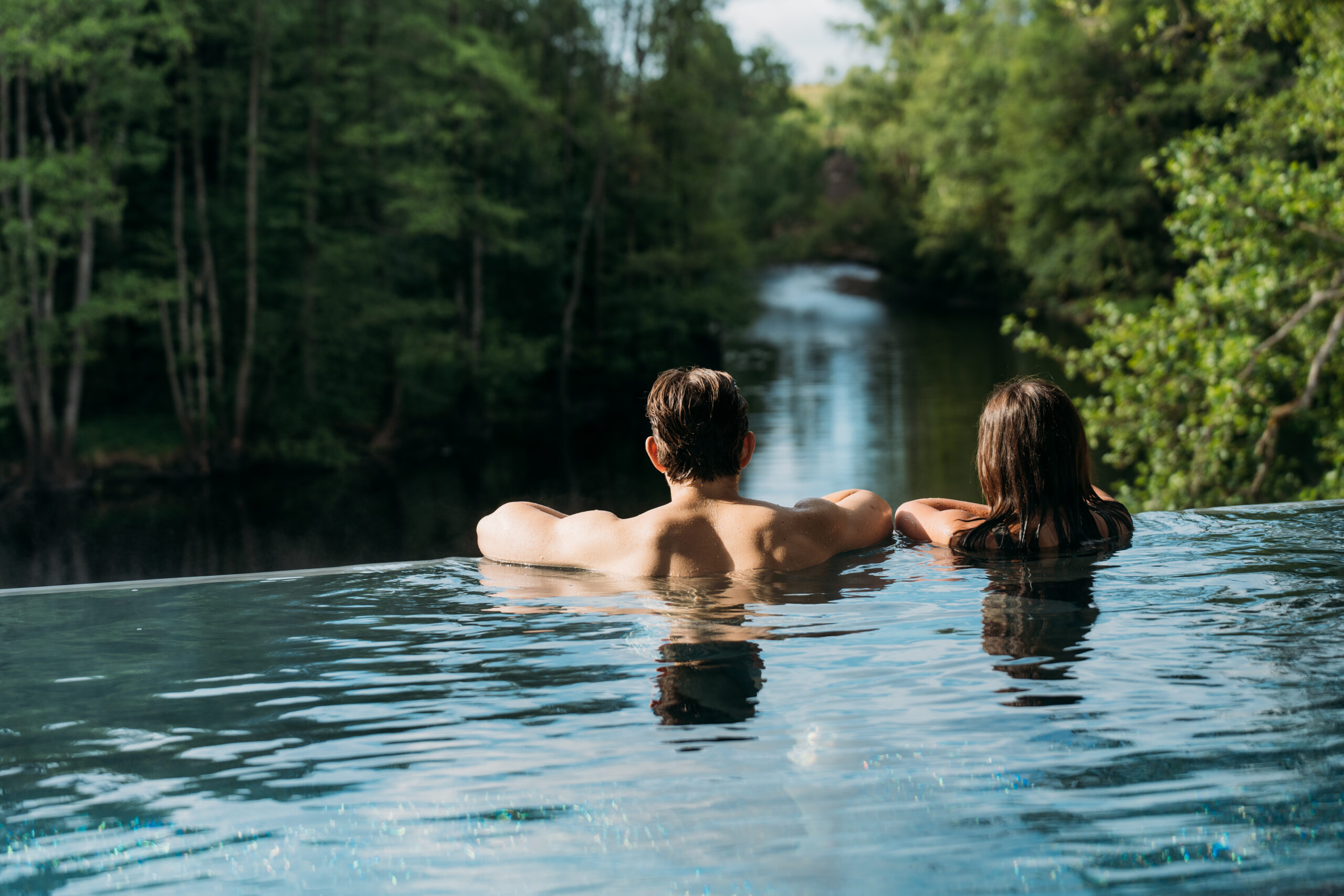 Två som blickar ut över Nissan från inifypoolen. Riverside Spa på Hestraviken erbjuder dagspa med varma pooler och avkopplande behandlingar i en lugn och naturskön miljö