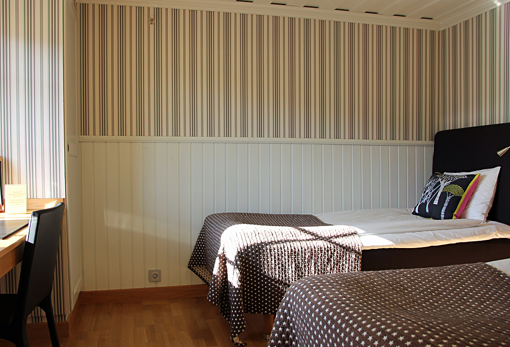 Sovrum med två separata sängar i en av småstugorna på Hestraviken hotell och spa vida Isaberg i Småland