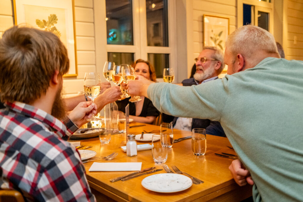 Deltagare i en konferensgrupp förenas i en gemensam skål innan deras middag serveras i vår restaurang