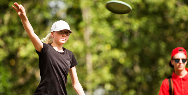 Två ungdomar spelar discgolf på Isaberg