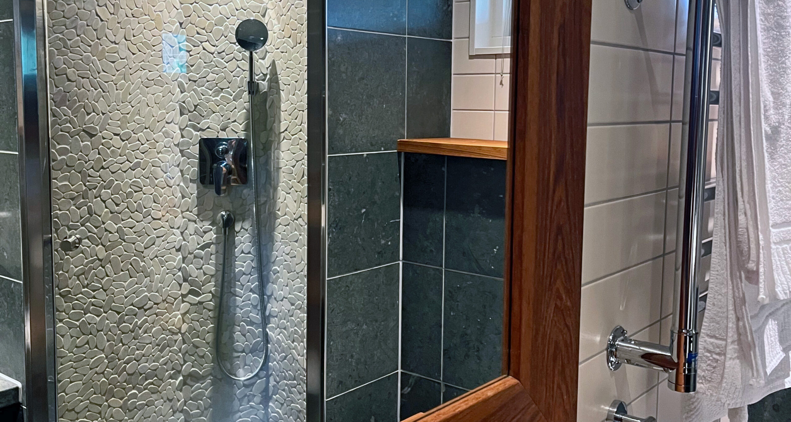 Dusch och spegel i ett av badrummen i villa 1 på Hestraviken hotell och spa vid Isaberg i Småland