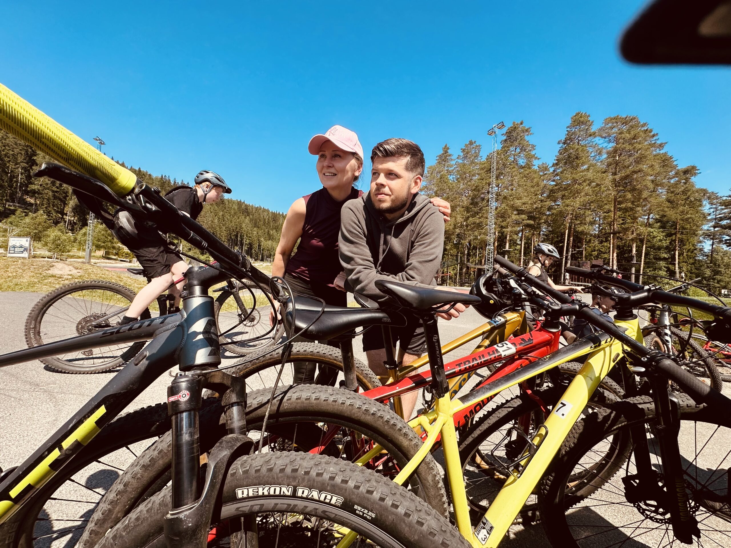En kvinna och en man lutar sig över sina hyrda mountainbikes från Hestraviken efter att ha cyklat Pink Lady-leden till Isabergs Bike Park och Sportcenter.