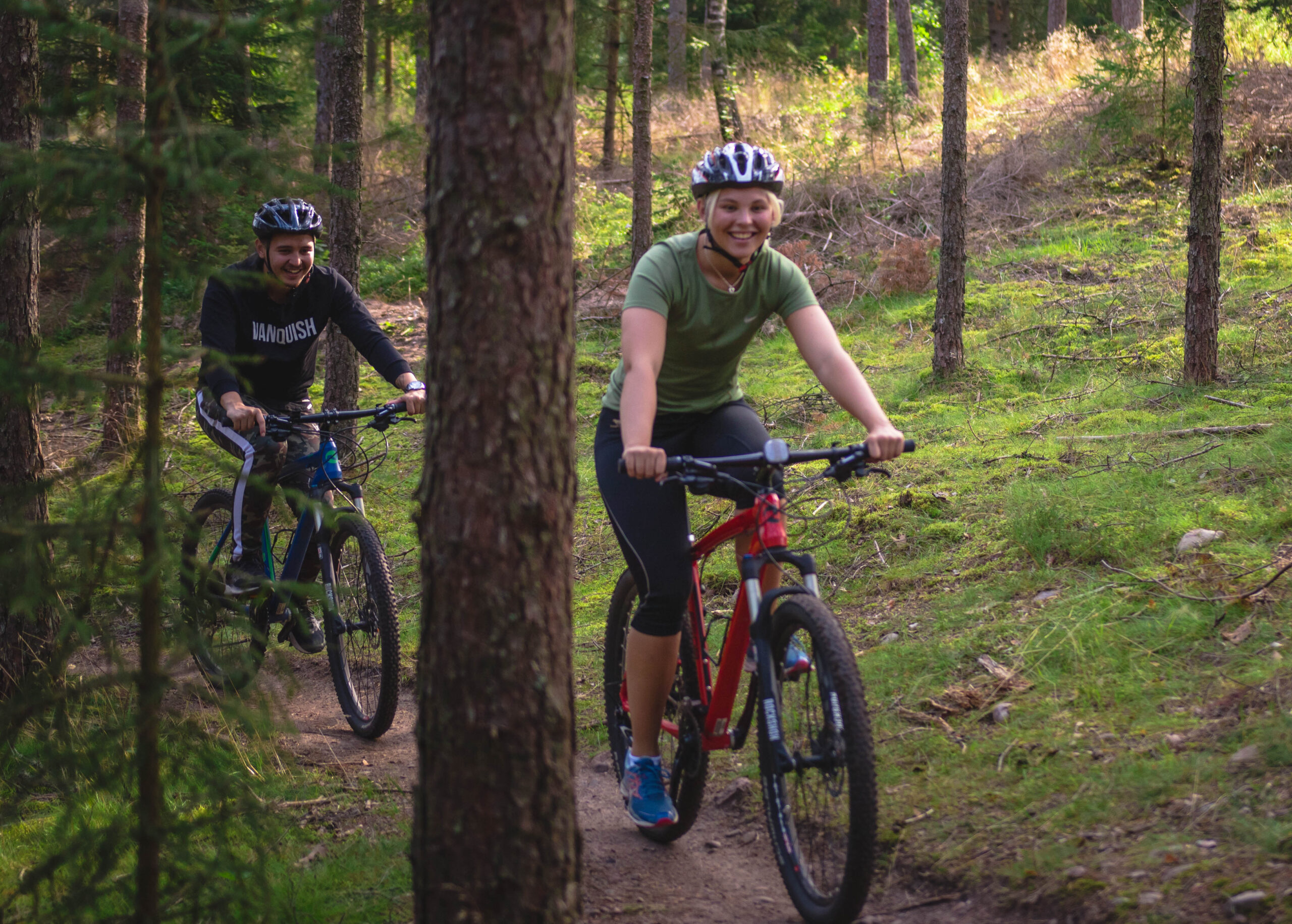 Tjej och kille som cyklar moutainbike på leden Pink lady mellan Hestraviken och Isaberg. Cyklarna är från Hestraviken hotell i Småland
