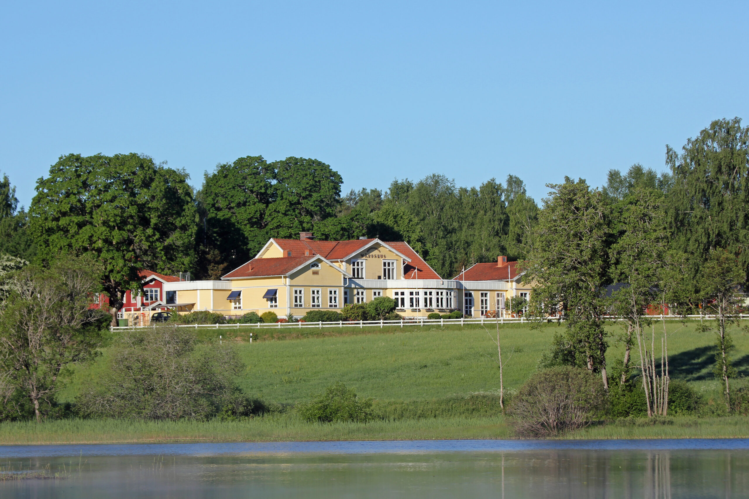 Hestravikens restaurang-villa från 1906, sedd från sjön, omgiven av naturskön miljö vid Isaberg i Småland.