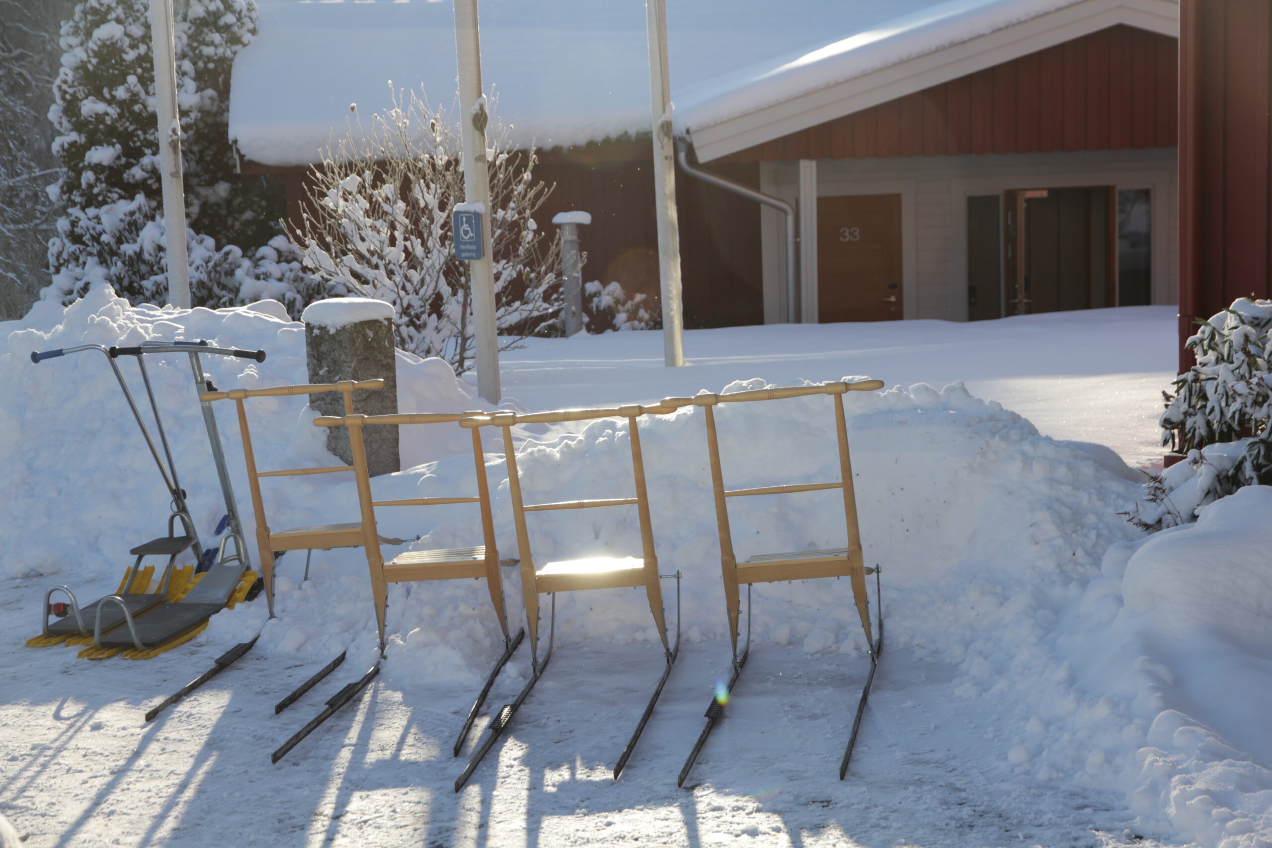 Sparkar parkerade i snön vid Receptionsvillan på Hestraviken, tillgängliga för hotellgäster att låna gratis.