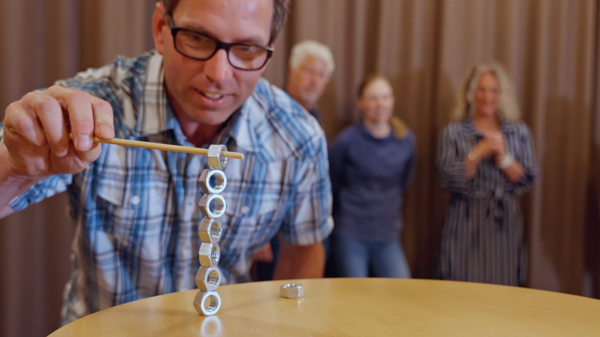 Koncentrerad mötesdeltagare i teamstärkande aktivitet med sina kollegor i bakgrunden