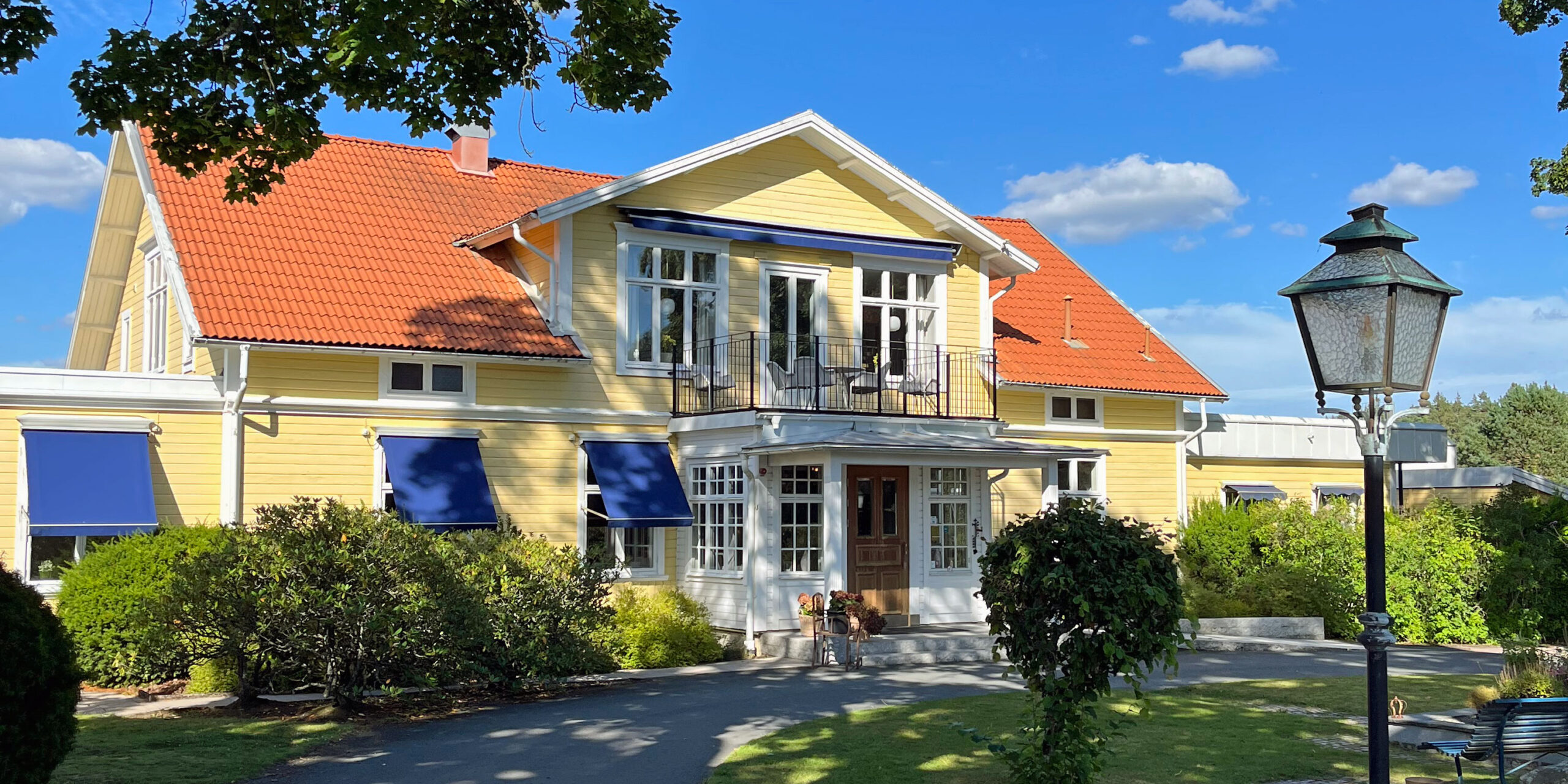 Restaurangvillan på Hestraviken, sedd från entrésidan, omgiven av lummig grönska.