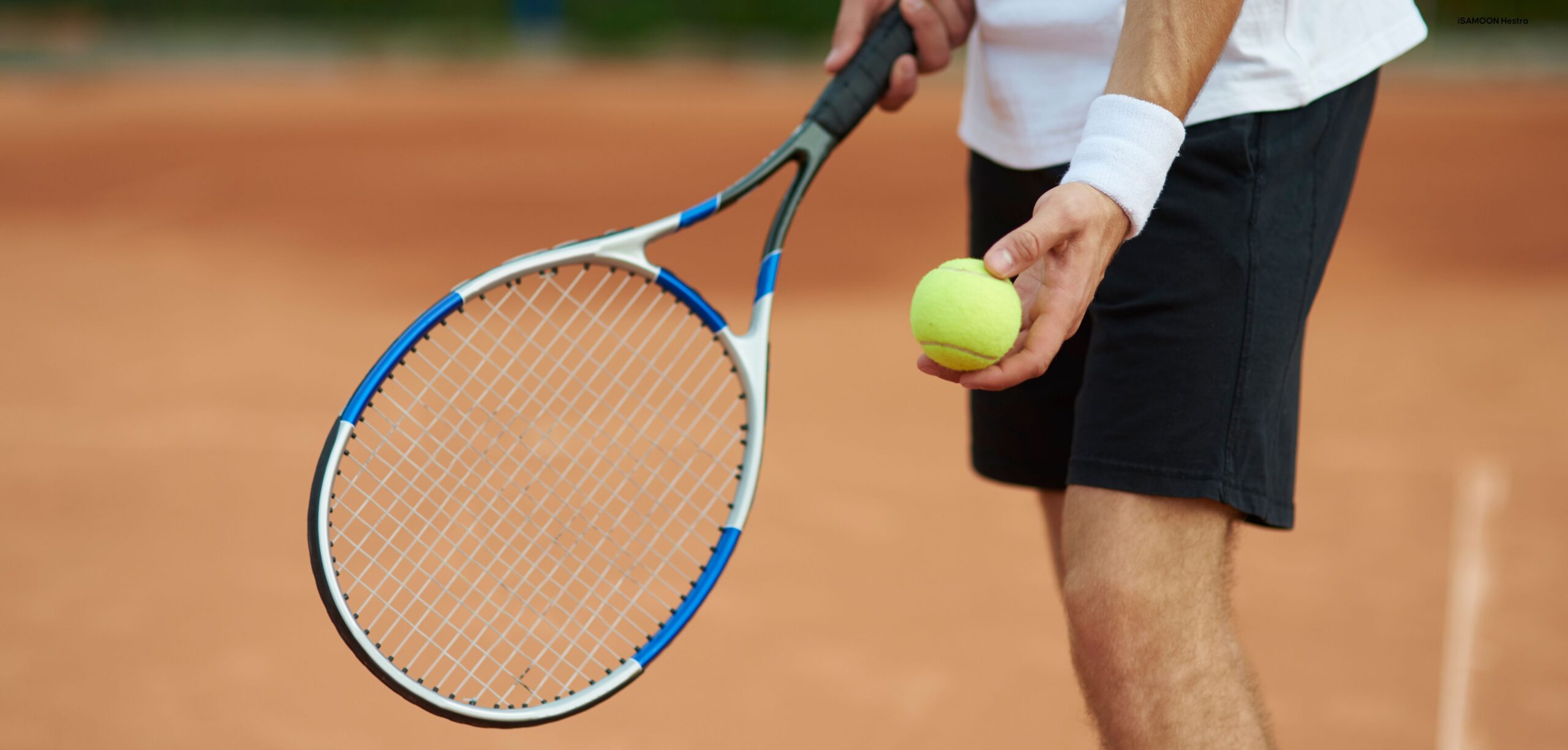 Man med racket och boll i hand redo för serve på utomhus tennisbana