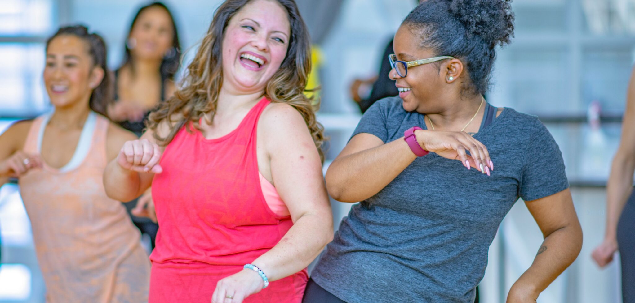 Två kvinnliga konferensdeltagare förenas i dansens glädje, rytmik och skratt