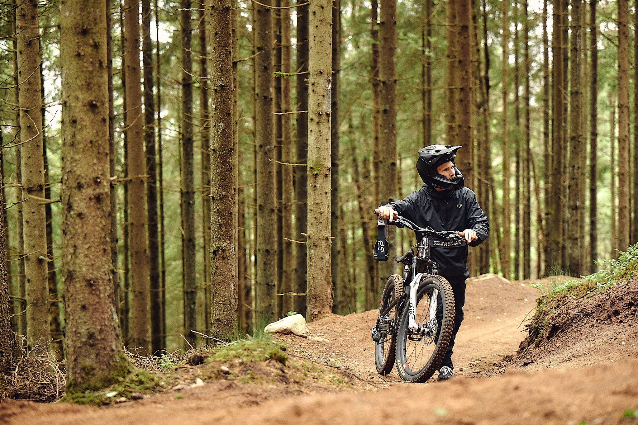 Man gåendes med mtb cykel uppför en av de preparerade banorna i skogen på Isaberg.