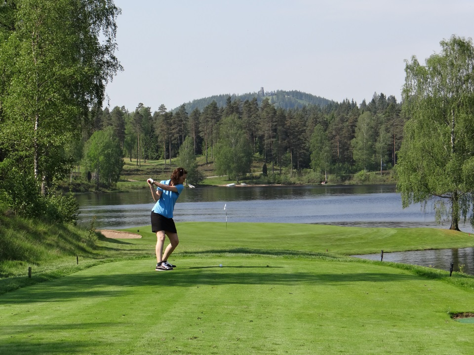 Kvinna på fairway Isaberg GK redo att slå in bollen på green med utsikt över Hammarsjön och Isaberg