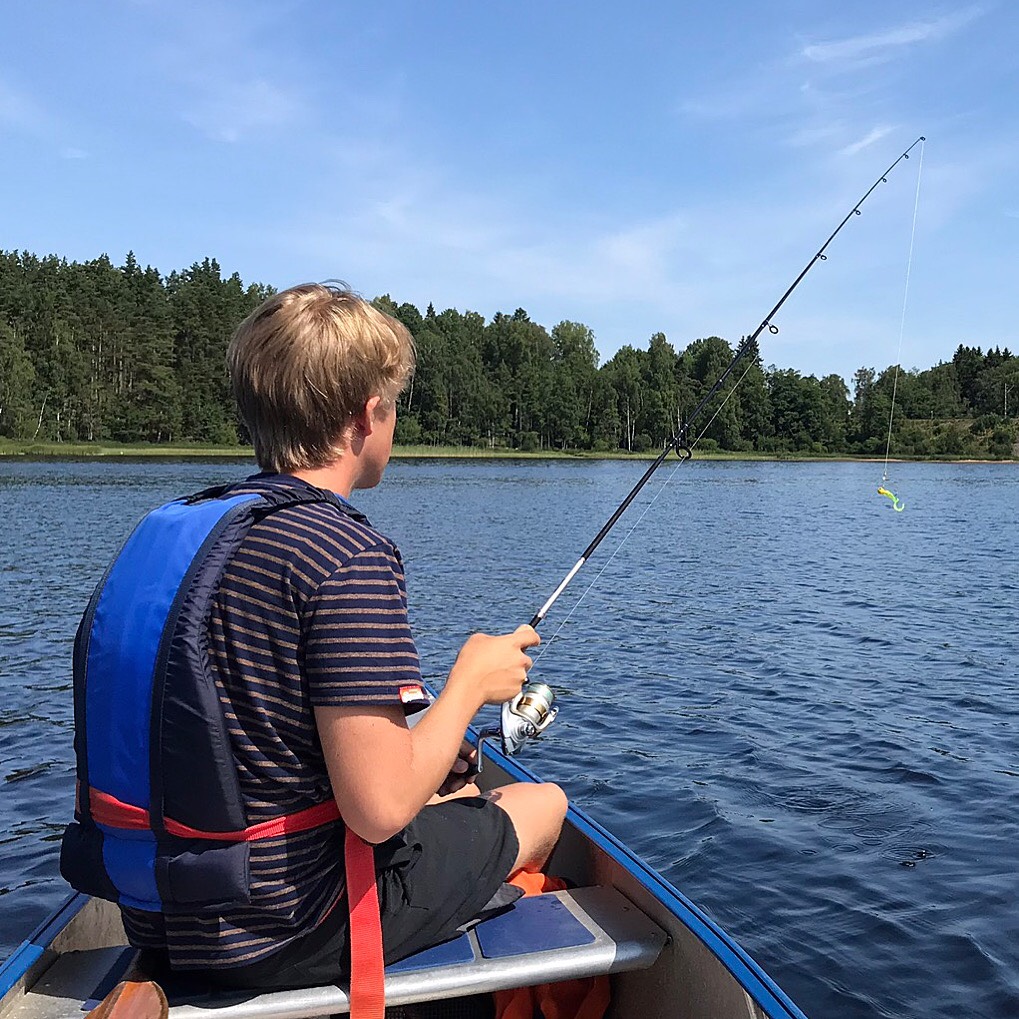 Kille fiskar med kastspö från en av Hestravikens kanoter i Vikaresjön