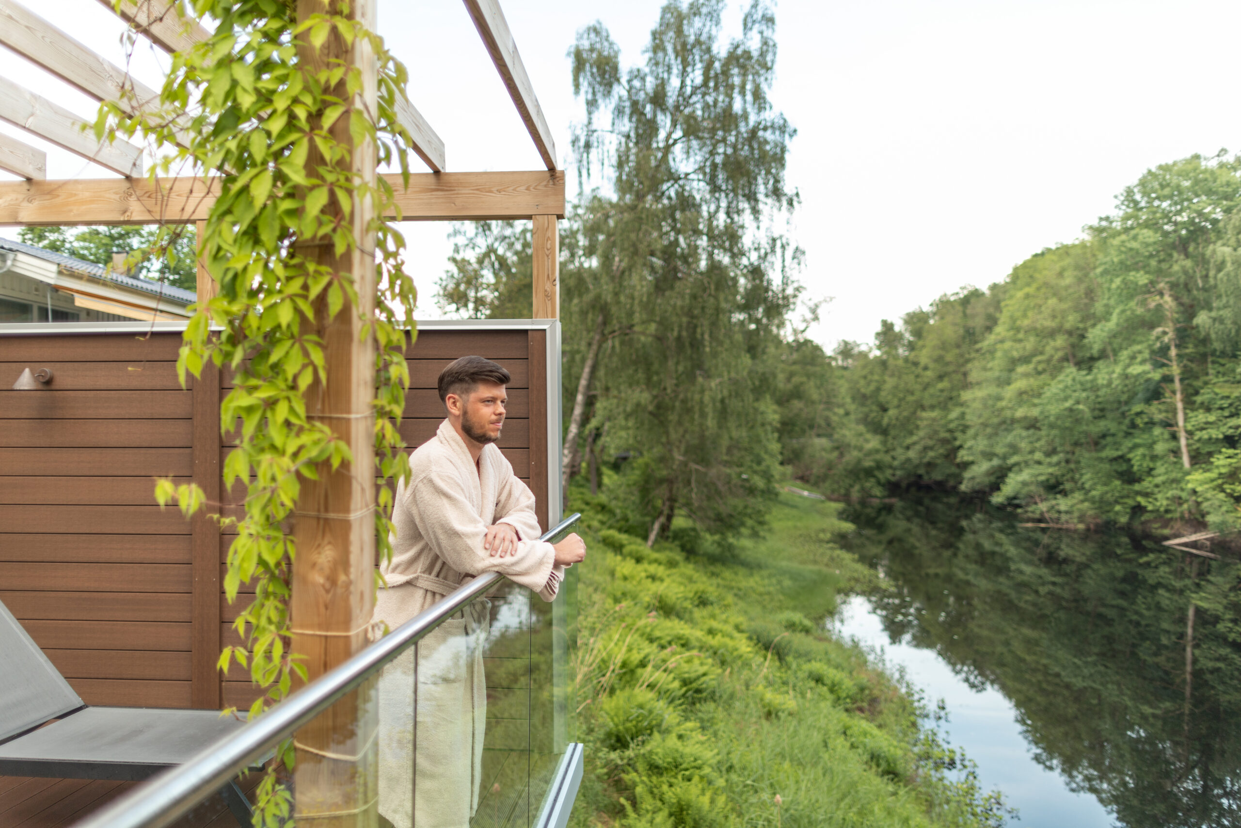 Kille som blickar ut över Nissan från Riverside spa på Hestraviken hotell i Småland.