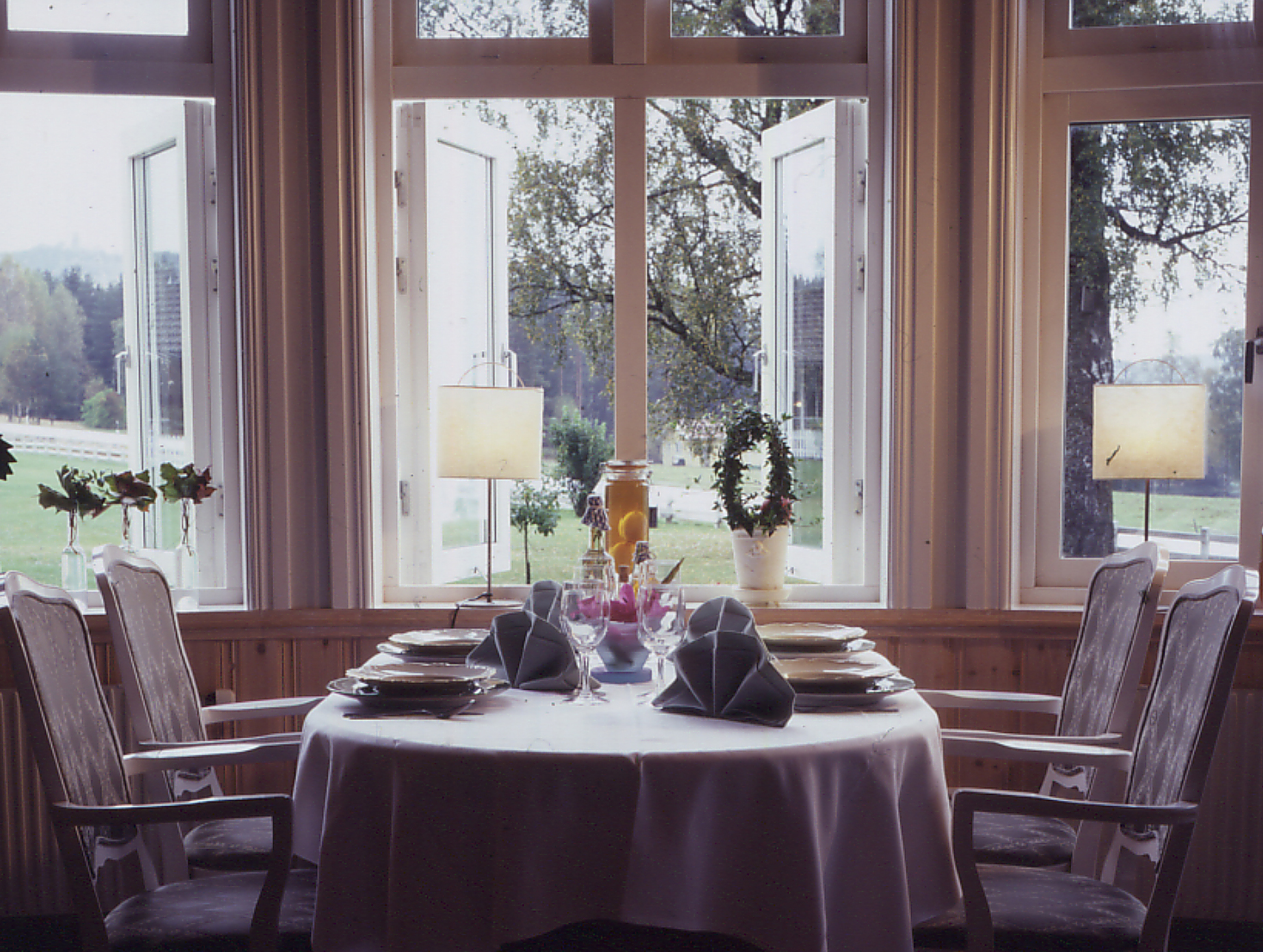 Historisk bild på dukat bord i Aquamatsalen med utsikt över Algustorpsjön Hestravikens Restaurang